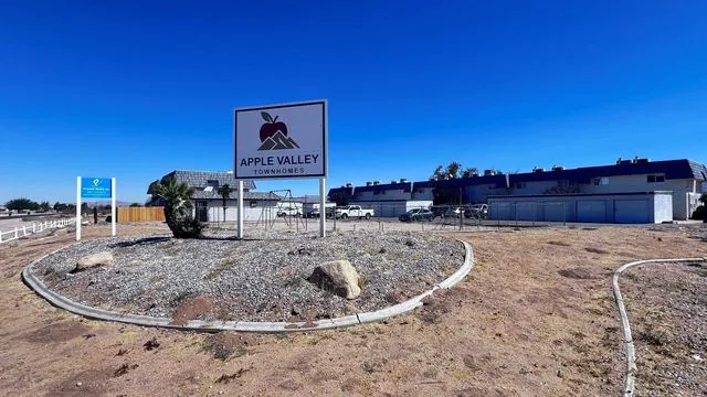 The entrance on Sioux Road with the property sign, townhomes and garages behind it